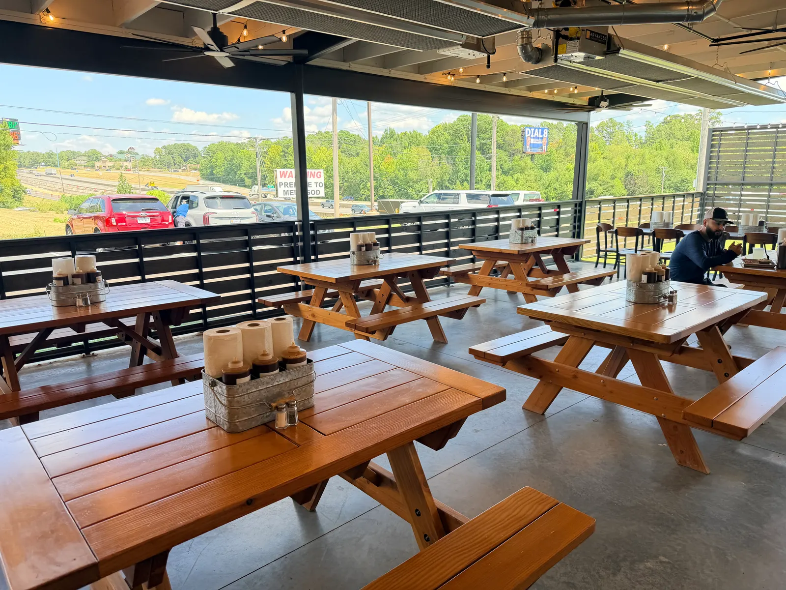 Outdoor patio seating with picnic tables and string lights at Wright's Barbecue in Benton