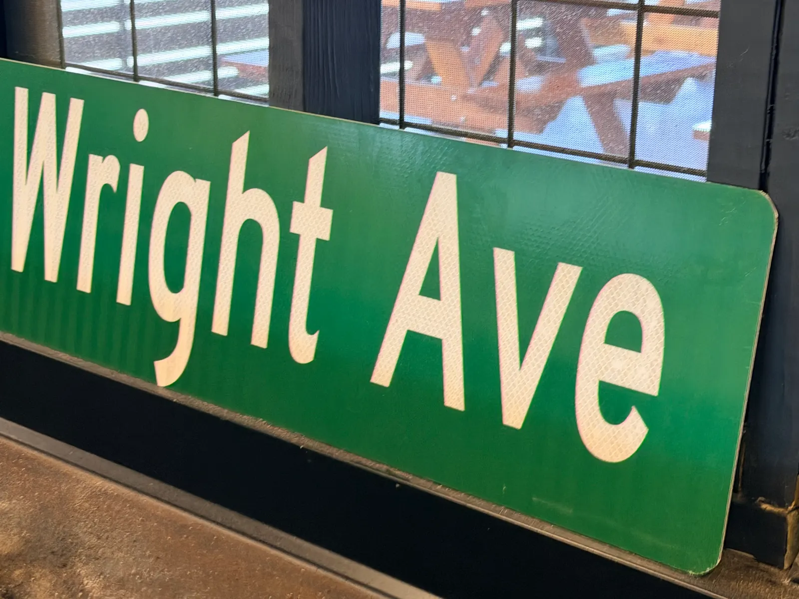 A green Wright Ave street sign displayed inside Wright's Barbecue in Benton
